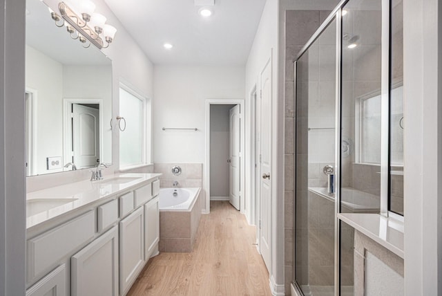 314 Wellshire Dr, West Columbia, TX 77486 - bathroom featuring a garden tub, wood finished floors, double vanity, a stall shower, and recessed lighting