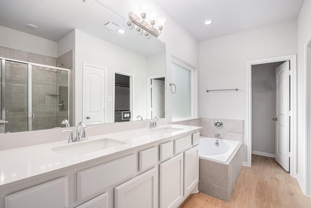 314 Wellshire Dr, West Columbia, TX 77486 - full bath featuring a stall shower, double vanity, a bath, and wood finished floors