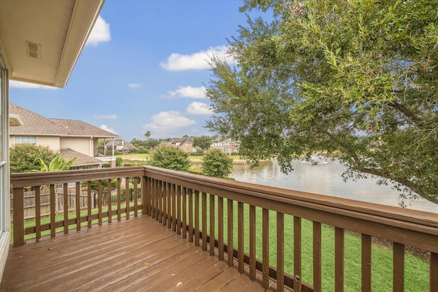 wooden deck featuring a water view and a lawn