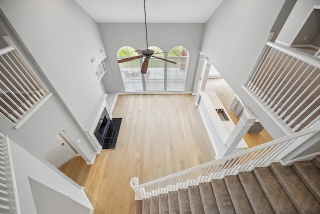 stairs with baseboards, ceiling fan, visible vents, and wood finished floors