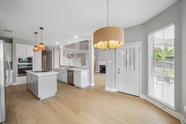 kitchen with visible vents, appliances with stainless steel finishes, white cabinets, and pendant lighting