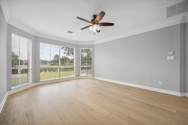 empty room with crown molding, ceiling fan, visible vents, and light wood-style floors