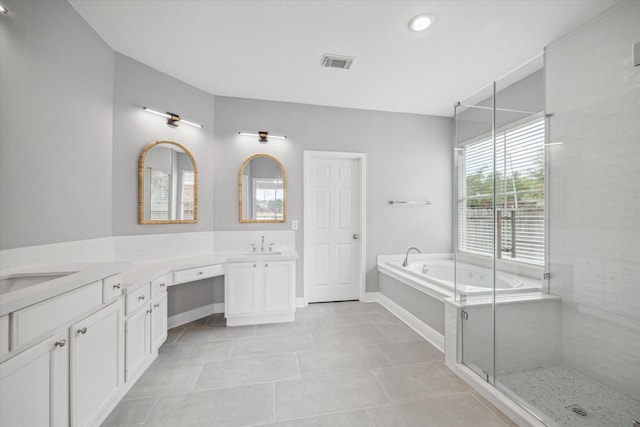 bathroom featuring a stall shower, visible vents, two vanities, a garden tub, and a sink