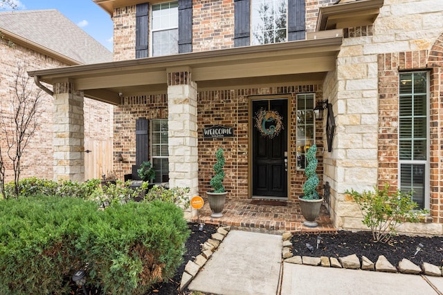 property entrance with stone siding, brick siding, and a porch