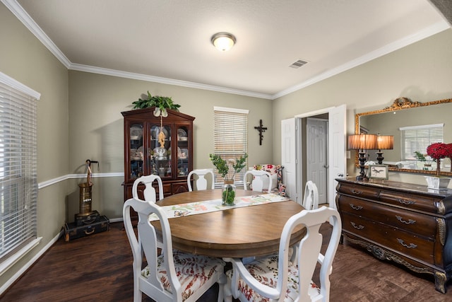 dining room with visible vents, ornamental molding, dark wood finished floors, and baseboards