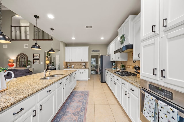 kitchen featuring visible vents, hanging light fixtures, appliances with stainless steel finishes, white cabinetry, and a sink