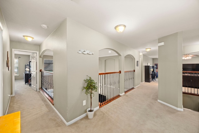 corridor with light colored carpet and baseboards