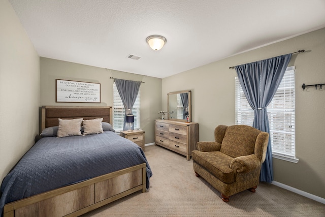 bedroom with light carpet, visible vents, and baseboards