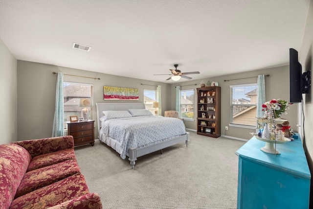 bedroom featuring visible vents, light carpet, baseboards, and multiple windows