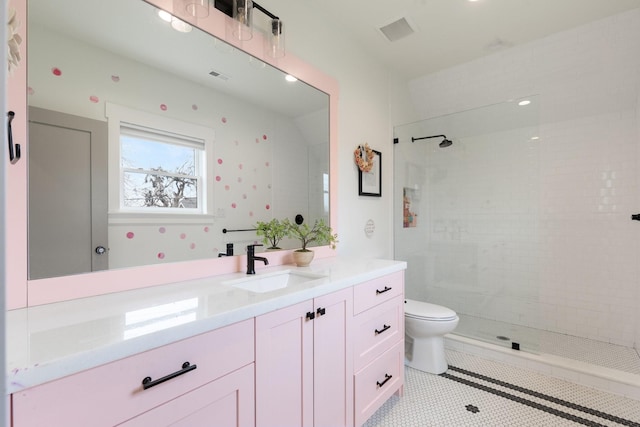 bathroom with toilet, vanity, visible vents, tiled shower, and tile patterned floors