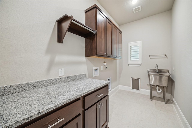 clothes washing area featuring hookup for a washing machine, hookup for an electric dryer, visible vents, baseboards, and cabinet space