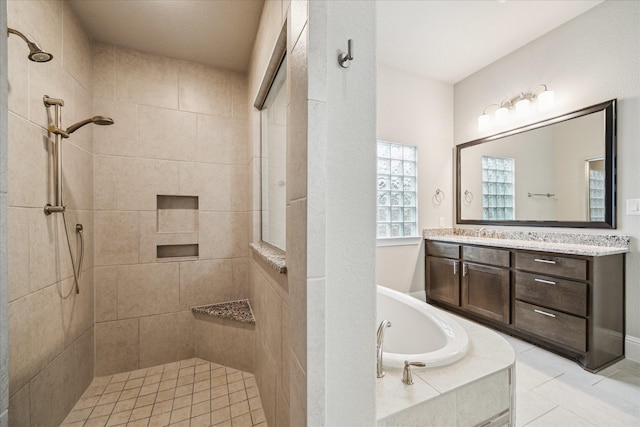 bathroom featuring a garden tub, tile patterned floors, a tile shower, and vanity