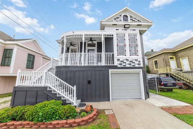 view of front of home with a garage, fence, a ceiling fan, concrete driveway, and stairway