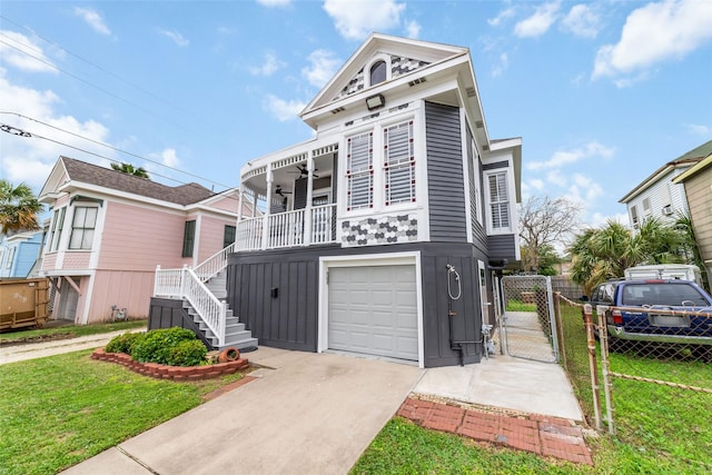 view of front of home with a garage, concrete driveway, a gate, a front lawn, and board and batten siding