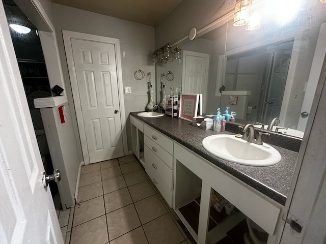 full bath with double vanity, tile patterned flooring, and a sink