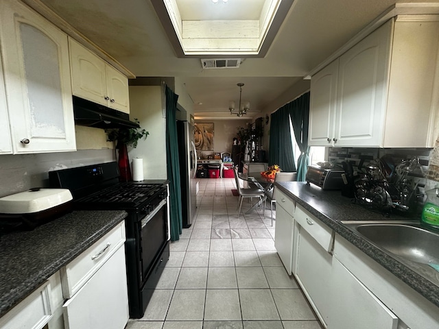 kitchen with dark countertops, black gas range, visible vents, and under cabinet range hood