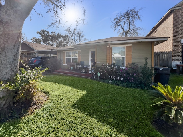 rear view of property with a lawn and fence