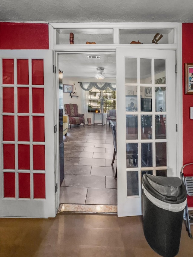 doorway with a ceiling fan and visible vents