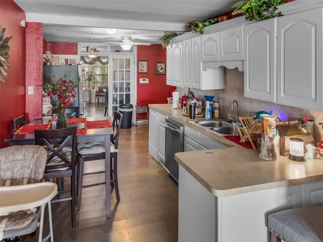 kitchen with light wood finished floors, ceiling fan, appliances with stainless steel finishes, light countertops, and a sink