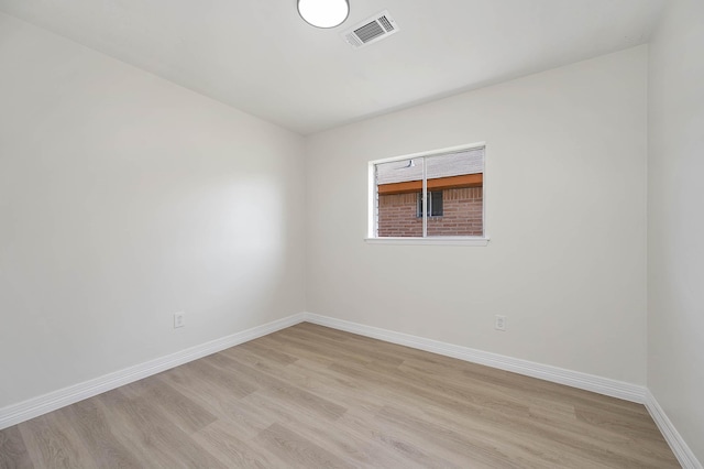 unfurnished room featuring baseboards, visible vents, and light wood finished floors