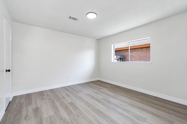 unfurnished room featuring visible vents, baseboards, and wood finished floors