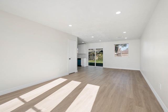 unfurnished room with light wood-type flooring, baseboards, and recessed lighting