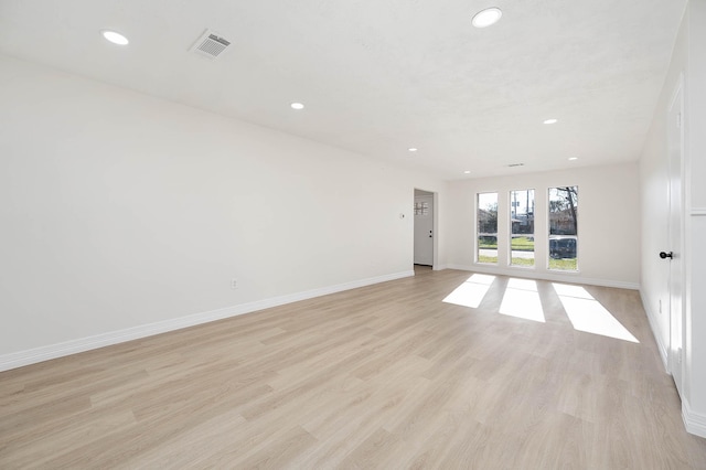 empty room with light wood finished floors, baseboards, visible vents, and recessed lighting