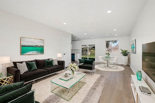 living room with baseboards, wood finished floors, and recessed lighting