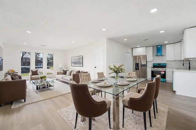 dining space featuring light wood finished floors, visible vents, and recessed lighting