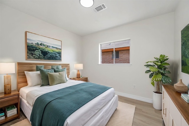 bedroom featuring baseboards, visible vents, and light wood-style floors