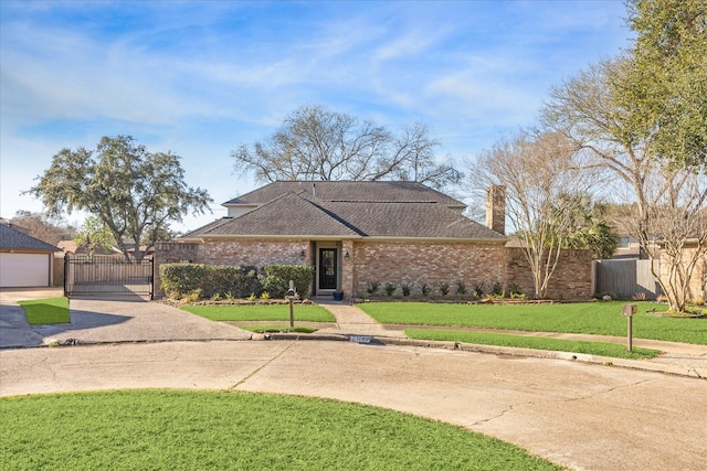 view of front of house with brick siding, a shingled roof, fence, a gate, and a front lawn