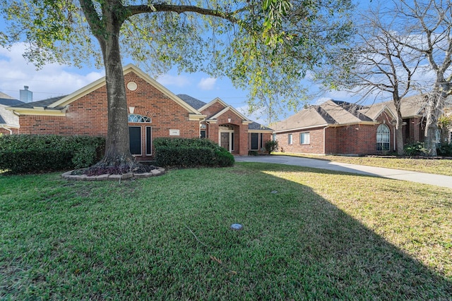 view of front of house featuring brick siding and a front lawn