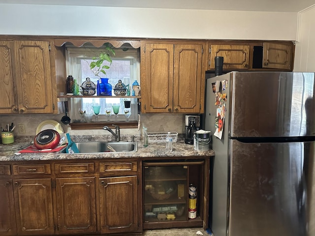 kitchen featuring freestanding refrigerator and a sink