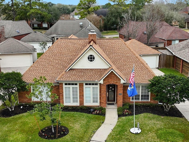 traditional-style house featuring a front yard, a chimney, and brick siding