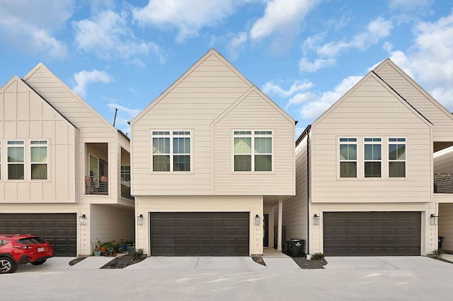 view of front facade featuring board and batten siding, driveway, and an attached garage