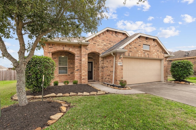 view of front of property featuring a garage, a front yard, brick siding, and driveway