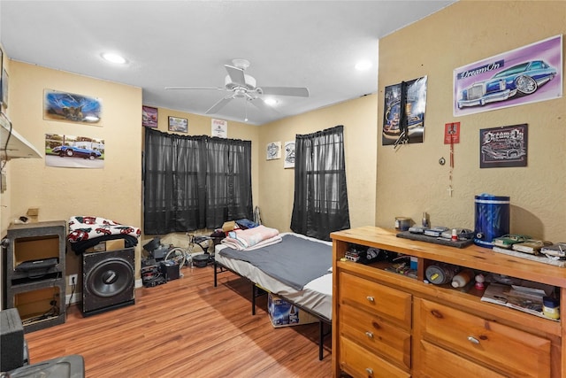 bedroom featuring light wood-style floors, recessed lighting, a ceiling fan, and a textured wall