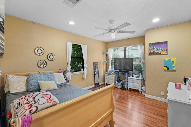 bedroom featuring ceiling fan, recessed lighting, wood finished floors, visible vents, and baseboards