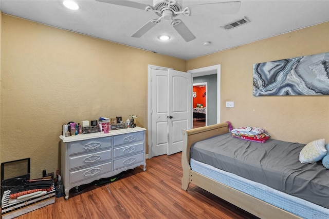 bedroom featuring dark wood finished floors, visible vents, and a ceiling fan