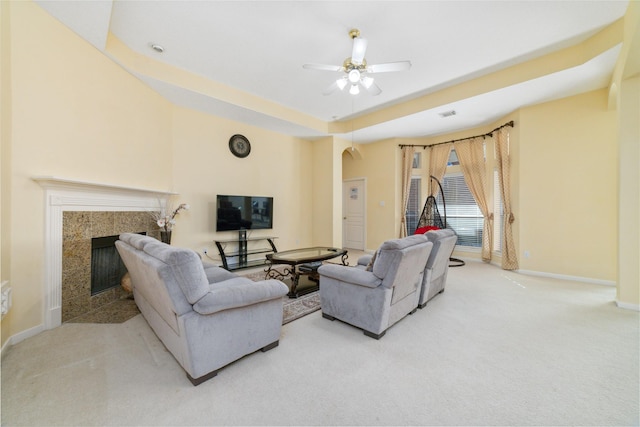 living area with carpet, arched walkways, a premium fireplace, a ceiling fan, and baseboards