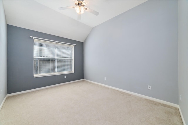 spare room featuring lofted ceiling, light carpet, ceiling fan, and baseboards