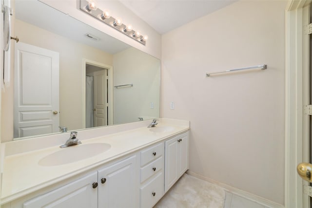 full bath featuring double vanity, baseboards, visible vents, and a sink