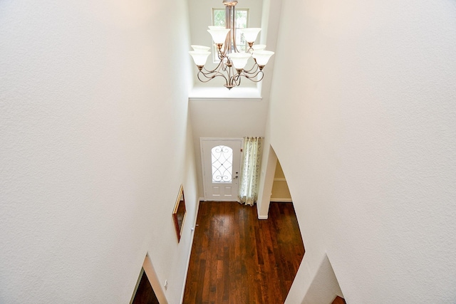 entryway with a chandelier and dark wood finished floors