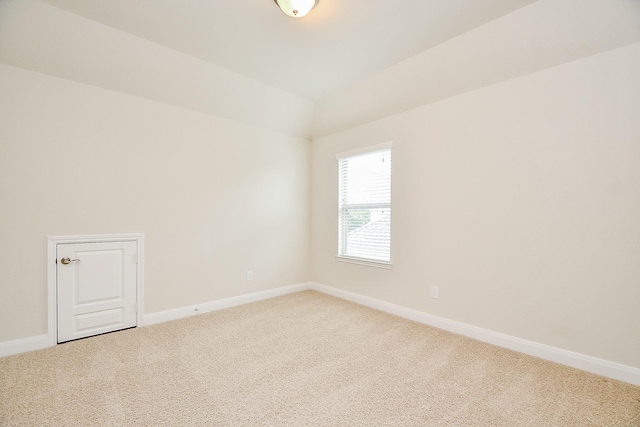 carpeted spare room featuring baseboards