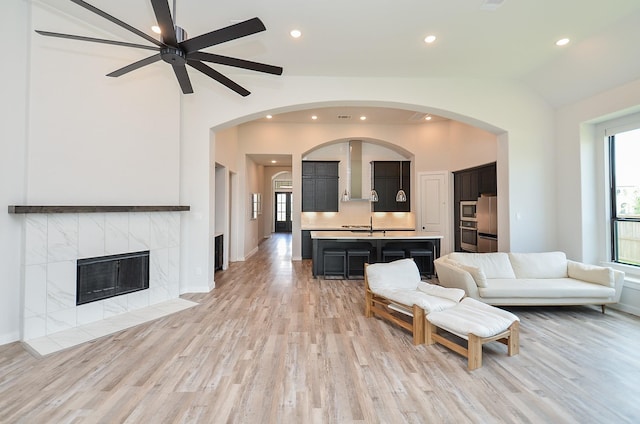 living area with light wood finished floors, a wealth of natural light, and ceiling fan