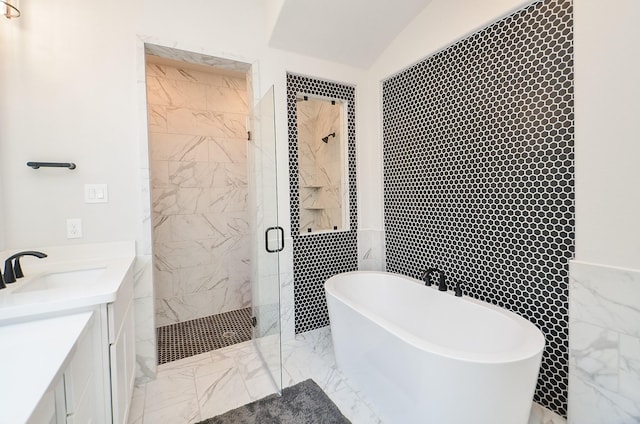 full bathroom featuring a shower stall, a freestanding bath, vanity, marble finish floor, and tile walls