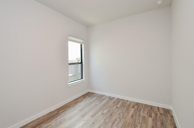 spare room with light wood-style floors and baseboards