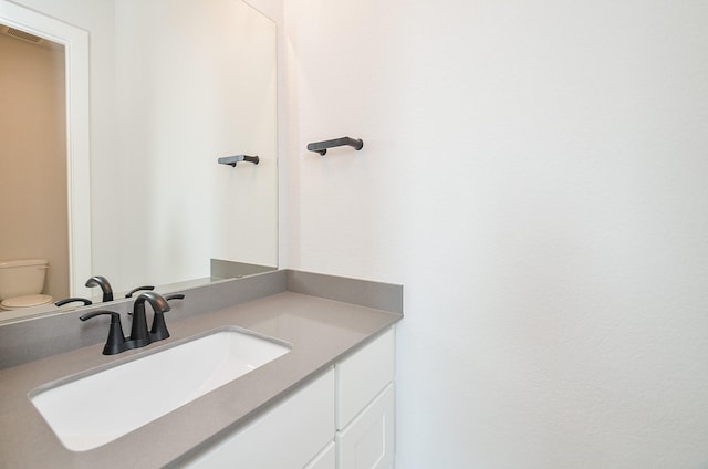 half bath featuring vanity, toilet, and visible vents