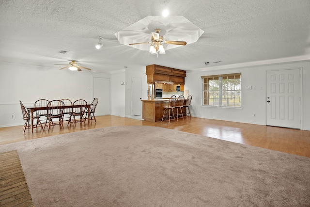 living room featuring a textured ceiling, visible vents, and a ceiling fan