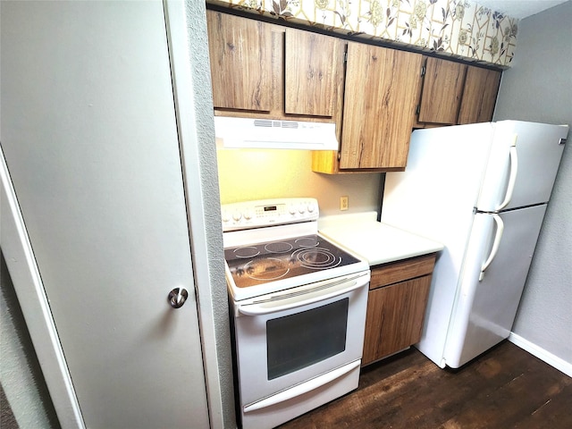 kitchen featuring range hood, light countertops, baseboards, white appliances, and dark wood-type flooring